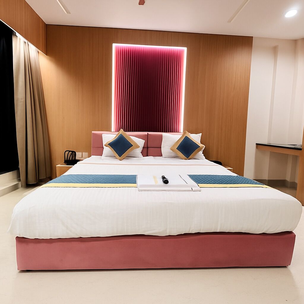 Ein modernes Hotelzimmer mit einem großen Bett, einer Holzpaneele, einem roten Vorhang und einem kleinen Schreibtisch mit Stuhl.
