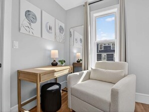 Una habitación moderna con escritorio, silla y una obra de arte en la pared.