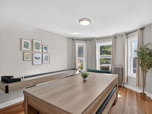 Una habitación moderna con una mesa larga, una obra de arte enmarcada en la pared y una planta en maceta.
