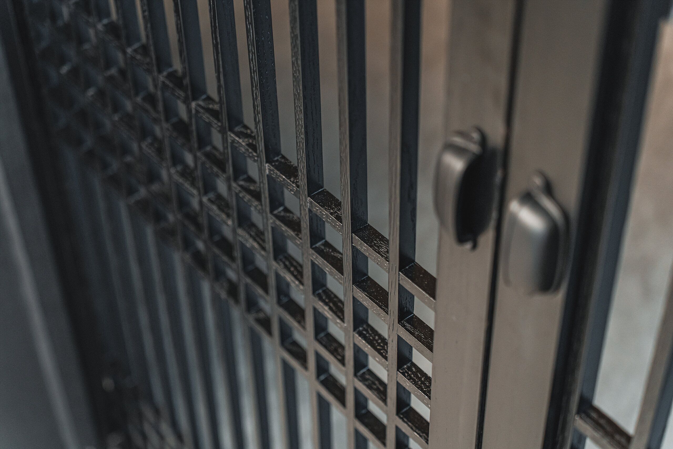 A close-up of a metal security gate with vertical bars and a keyhole.