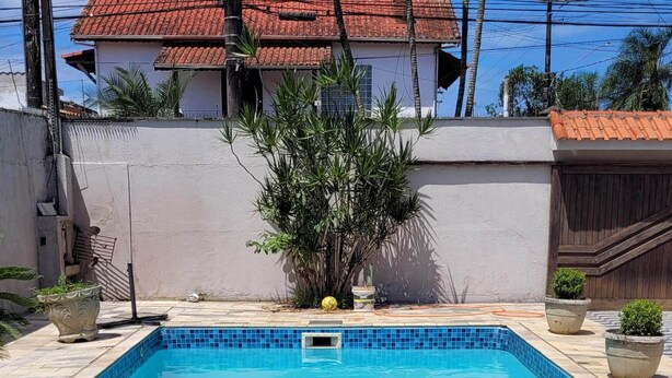 Una piscina rectangular con borde alicatado, rodeada de baldosas de piedra.