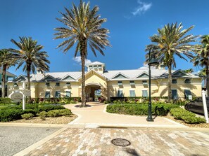 A large, two-story building with a central entrance, surrounded by palm trees and well-maintained landscaping. - Oceanfront beauty in Cinnamon Beach - 824! (Palm Coast)