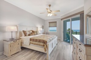 A bedroom with a bed, nightstand, dresser, and a view of the ocean through a sliding glass door. - Oceanfront beauty in Cinnamon Beach - 824! (Palm Coast)