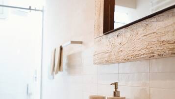Une salle de bain moderne avec une grande baignoire, un meuble-lavabo en bois et un miroir au-dessus du lavabo.