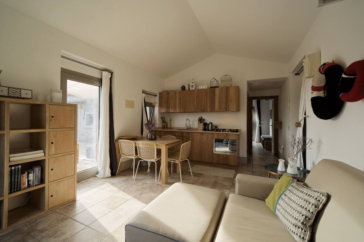 A modern living space with a dining area, kitchen, and seating area.