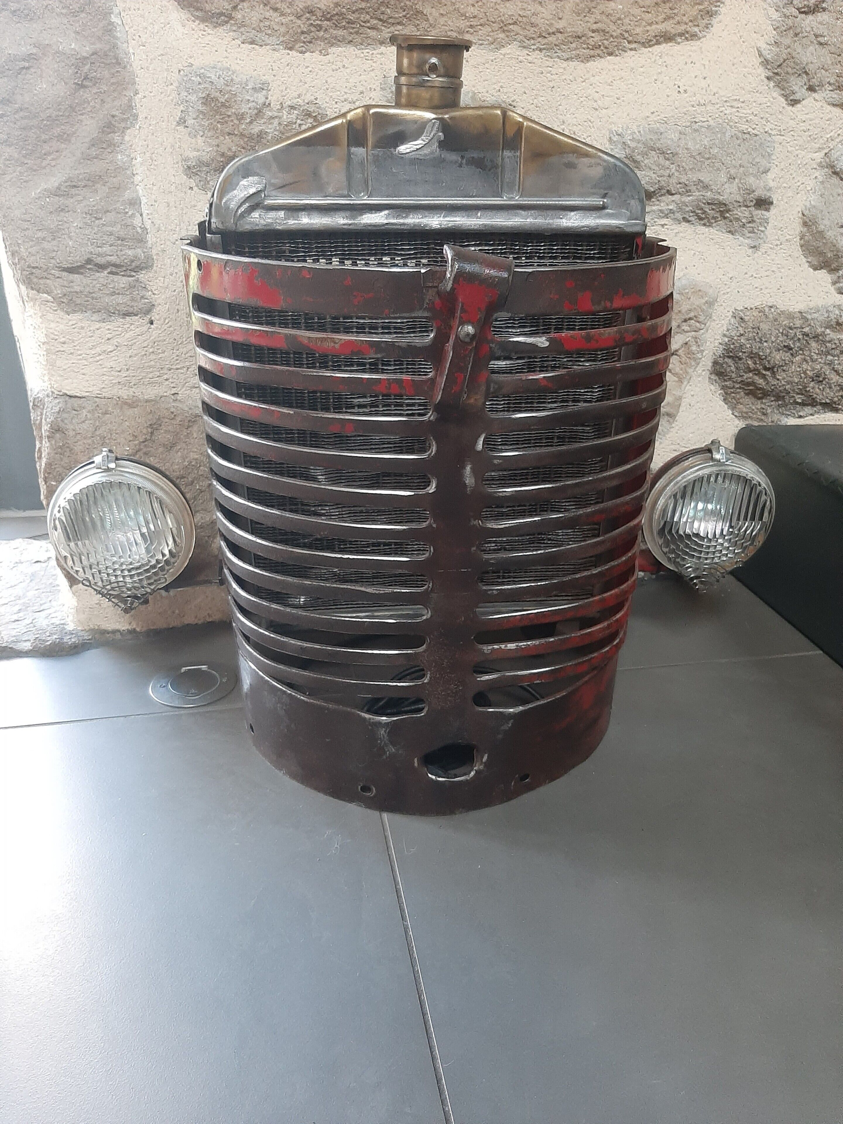 Una radio d'epoca con un coperchio trasparente, una griglia centrale e due altoparlanti laterali.