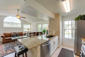 A modern kitchen with a central island, stainless steel appliances, and large windows. - 8 Mi to Disney: Resort-style Condo w/ Pool Access (Kissimmee)