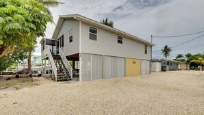 A two-story building with a covered outdoor area and a staircase leading to the upper floor. - Canal-front Florida Keys Home w/ Private Dock (Marathon)