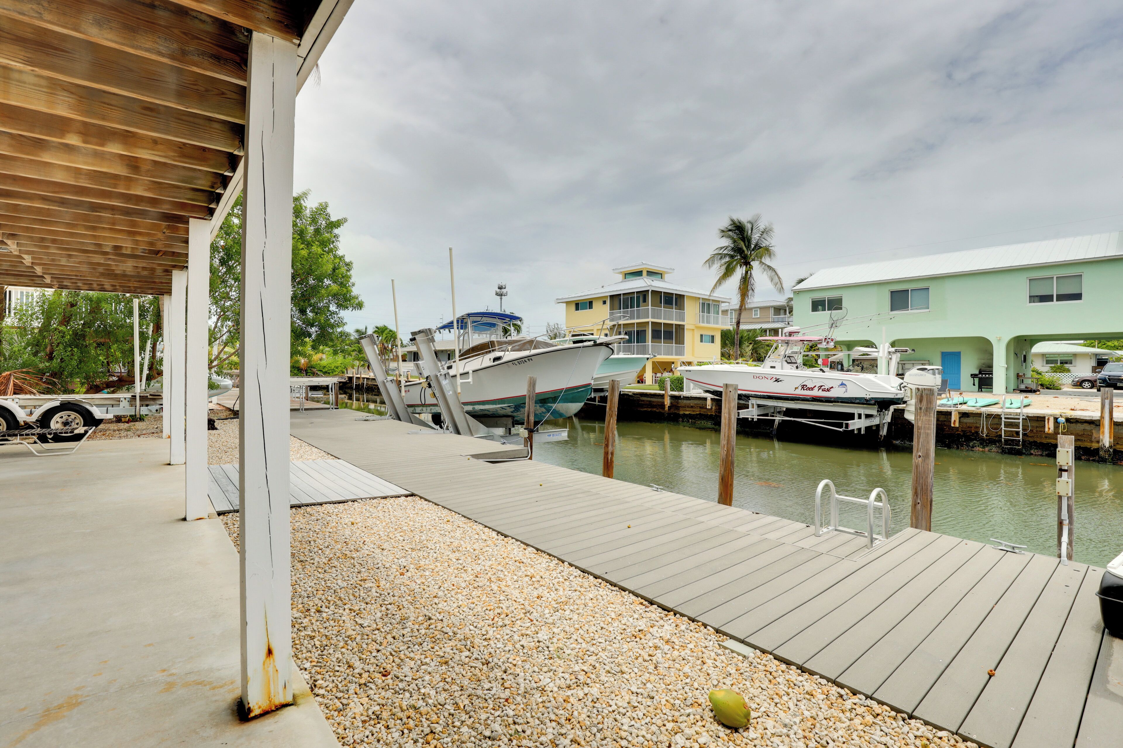 Un port de plaisance avec des bateaux amarrés, une passerelle couverte et un bâtiment doté d’un balcon.