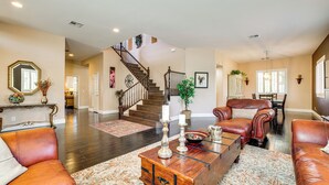 A spacious living room with leather sofas, a wooden coffee table, and a staircase leading to another level. - Las Vegas Escape w/ Private Outdoor Paradise (Las Vegas)