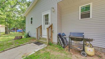 A house with a front porch, a grill, and a propane tank.
