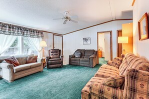 A living room with a ceiling fan, two couches, a chair, and a lamp. - Solberg Lake House: Dock, Deck + Stunning Views! (Phillips)