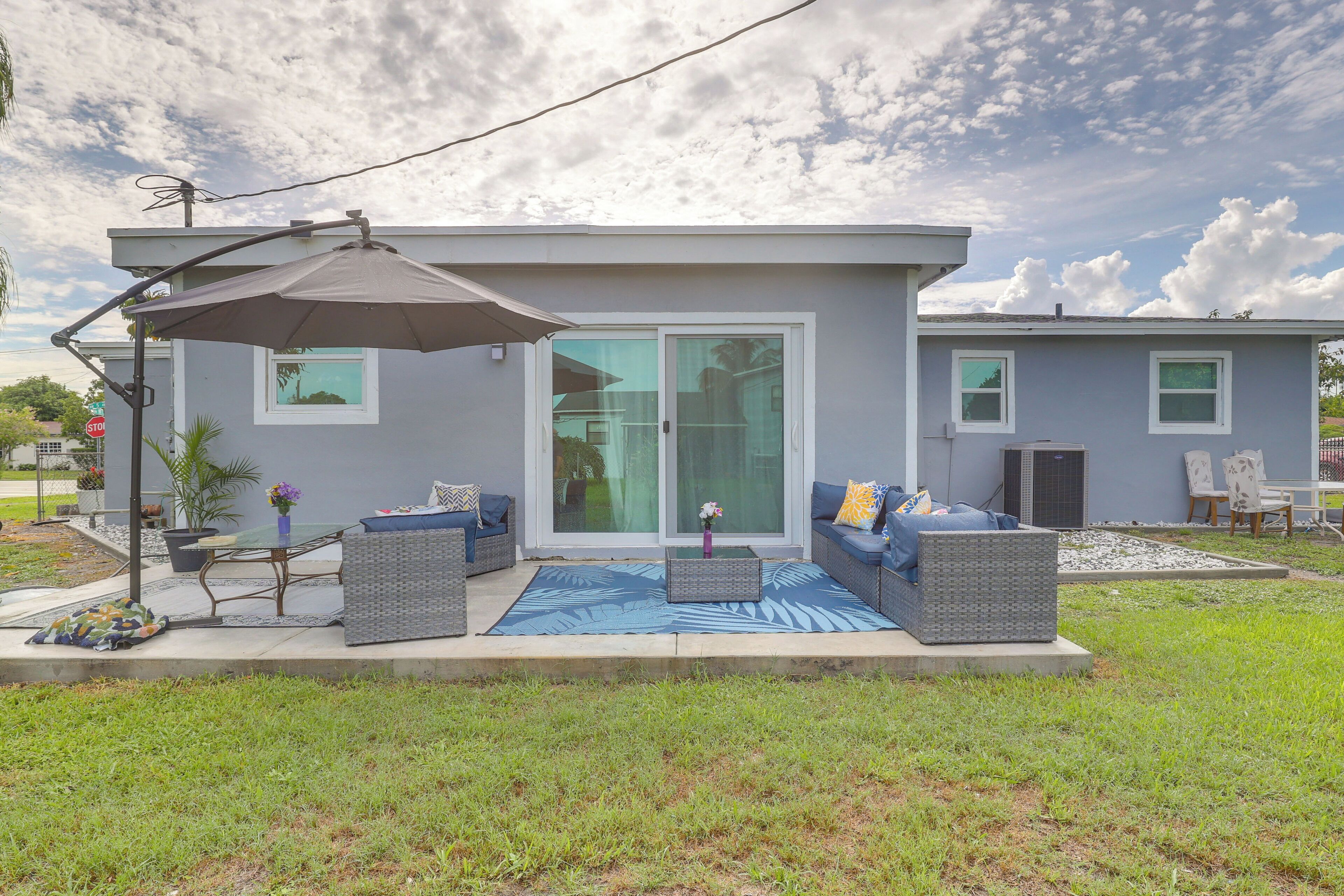 A modern house with a patio area featuring outdoor furniture and a large umbrella.