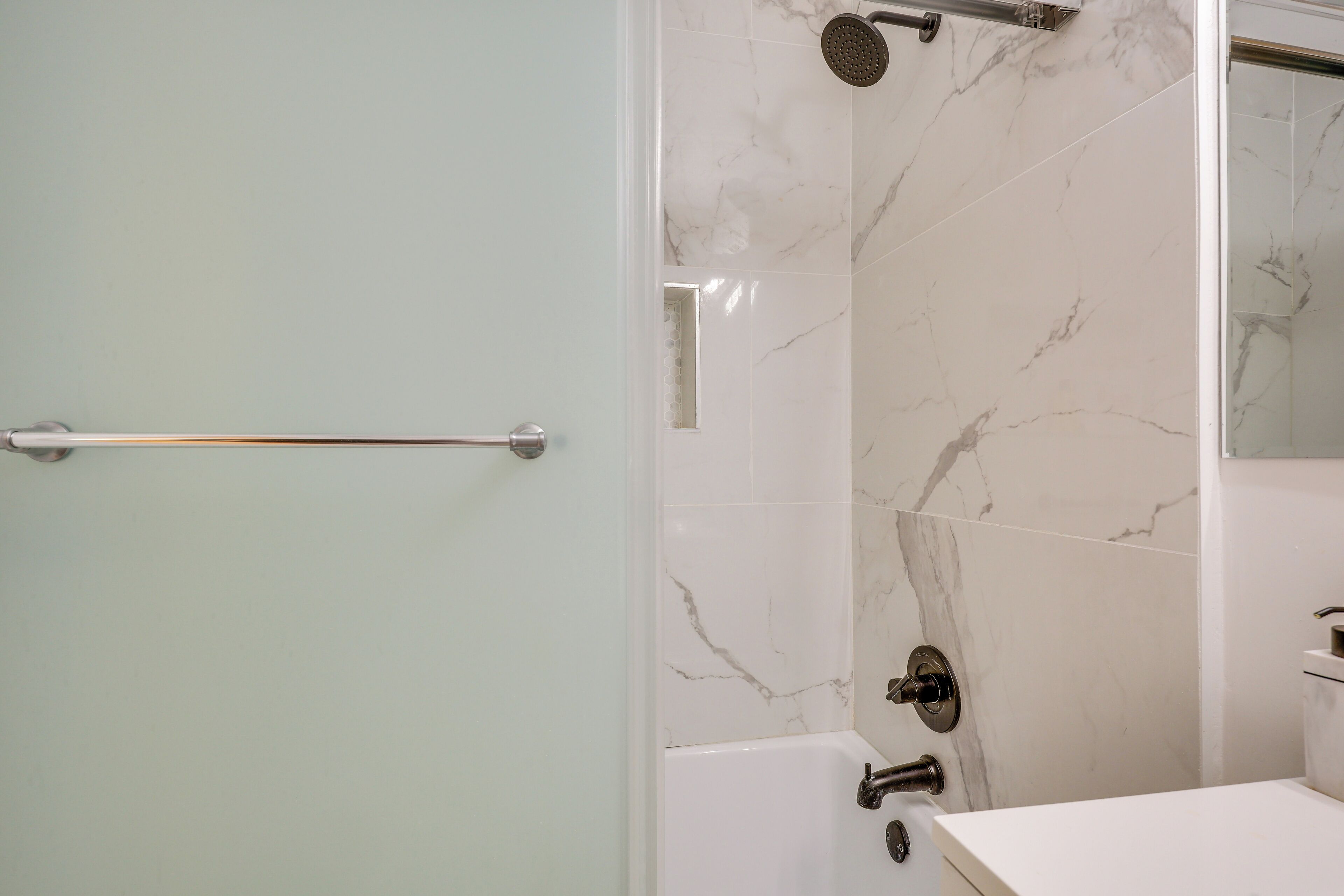 Een moderne badkamer met een douche, een bad en een wastafel.