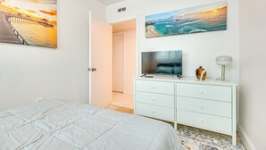 A bedroom with a bed, a dresser, a television, and two paintings on the wall. - 2 Mi to Hard Rock Stadium: Home w/ Spacious Yard (Miami Gardens)