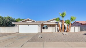 A single-story house with a garage, palm trees, and a gravel driveway. - 5 Mi to CO River: Home w/ Pool in Fort Mohave! (Fort Mohave)