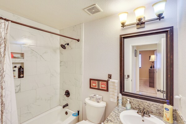 A bathroom with a shower, toilet, sink, and a large mirror. - 5 Mi to CO River: Home w/ Pool in Fort Mohave! (Fort Mohave)