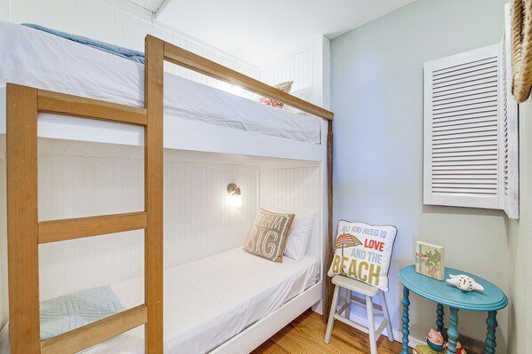A bunk bed with a wooden frame, a white mattress, and a pillow with the text "Dream BIG". There is a small table with a book and a decorative item. - Mtn-view Camano Island Retreat Overlooking Beach (Camano Island)