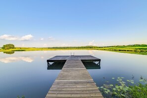 A wooden pier extending into calm water, surrounded by green fields and a clear sky. - Private Lake & Dock: Log Cabin, 2 Mi to Clay! (Clay)