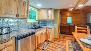 A kitchen with wooden cabinets, granite countertops, a dishwasher, and a sink. - Private Lake & Dock: Log Cabin, 2 Mi to Clay! (Clay)