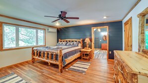 A bedroom with a wooden bed, a ceiling fan, large windows, and a wooden dresser. - Private Lake & Dock: Log Cabin, 2 Mi to Clay! (Clay)