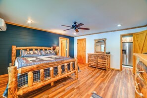 A bedroom with a wooden bed, a dresser, a mirror, and a ceiling fan. - Private Lake & Dock: Log Cabin, 2 Mi to Clay! (Clay)