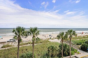 A beach with palm trees, a sandy shore, and a clear sky. - 3 BR, 3 BA Condominium in Myrtle Beach, Sleeps 6 (Myrtle Beach)