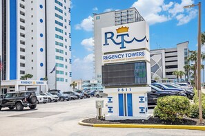 A building with a sign for 'Regency Towers' and a digital display.