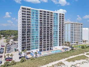 A high-rise hotel with multiple balconies, a swimming pool, and a beach view. - 3 BR, 3 BA Condominium in Myrtle Beach, Sleeps 6 (Myrtle Beach)