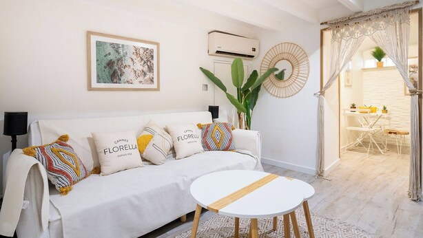 Un salon moderne avec un canapé, une table ronde et une grande plante.