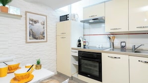 Une cuisine moderne avec des meubles blancs, un four à micro-ondes, une cuisinière et un évier.