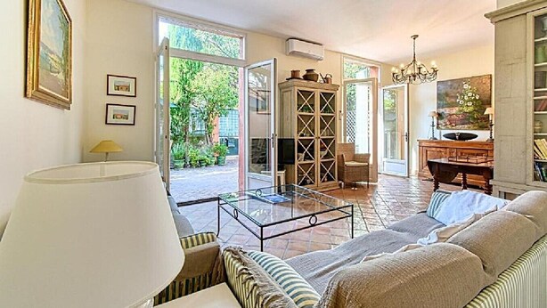 A living room with a sofa, a glass coffee table, a lamp, and a bookshelf. - L'Oranger maison pittoresque (Cannes)