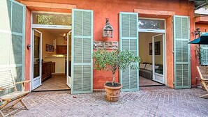 A building with open shutters, a potted tree, and a bench. - L'Oranger maison pittoresque (Cannes)