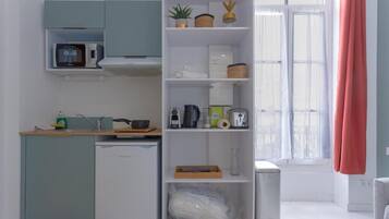 A compact kitchen with a microwave, coffee maker, and a small refrigerator.