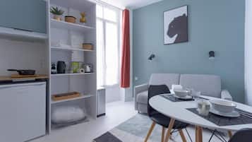 A compact living space with a kitchenette, a dining area, and a sofa.
