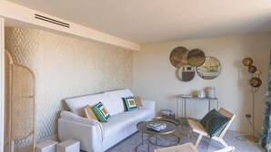 A modern living room with a white sofa, two armchairs, a coffee table, and a small side table.