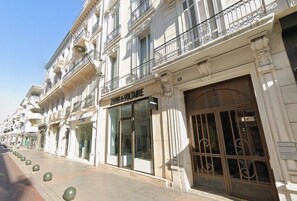 A row of white buildings with storefronts, including a visible sign for 'Jules & Voltaire.'