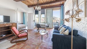 A spacious living room with a wooden ceiling, a sofa, a TV, and a dining area. - L'Honorat vue mer et port, à côté des plages (Cannes)