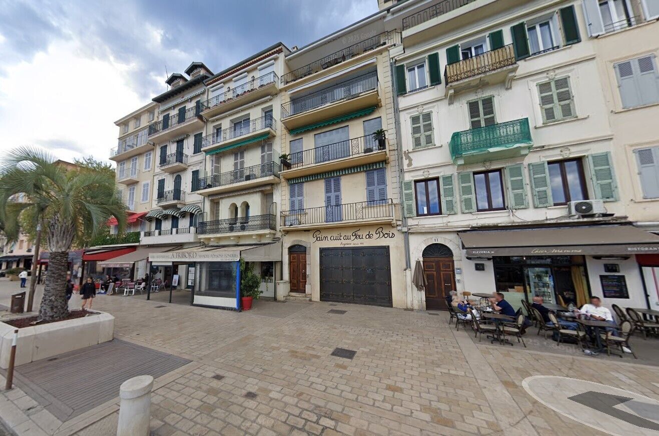 A multi-story building with balconies, a café, and outdoor seating.