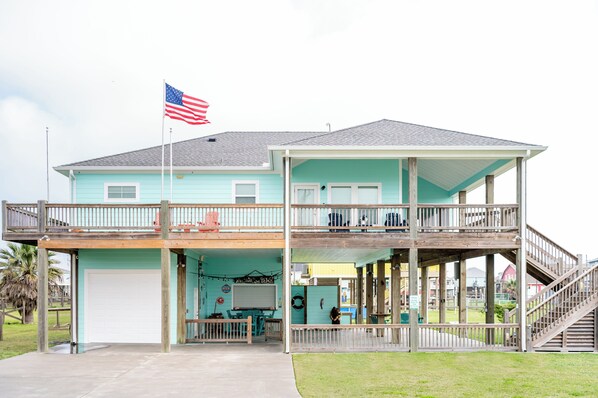 Ein zweistöckiges Gebäude mit Balkon, Flagge und Garage.
