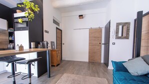 Una cocina moderna con barra, un mueble de madera y una mesa de comedor con taburetes de bar.