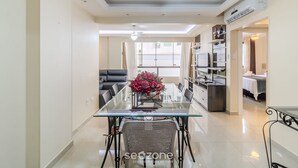 Un espace repas moderne avec une table en verre, des chaises en métal et un élément décoratif central.