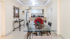 Un coin repas avec une table en verre, des chaises et un miroir décoratif.