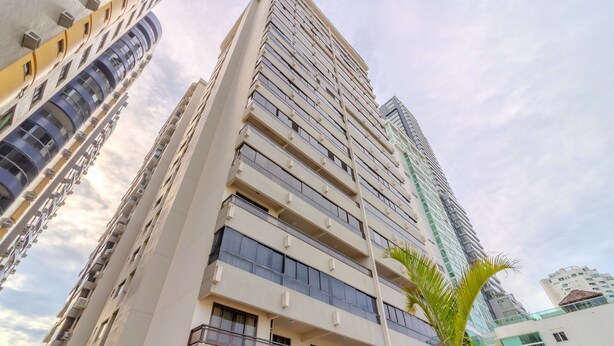 A high-rise building with multiple balconies and a modern architectural design.