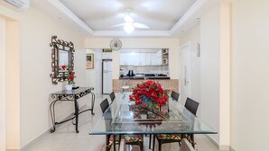 A dining area with a glass table, chairs, and a decorative mirror. - 2BR Full apt Beachfront Ese0102 (Balneário Camboriú)