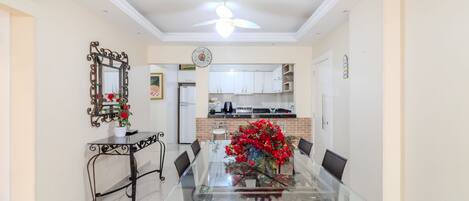 A dining area with a glass table, chairs, and a decorative mirror.