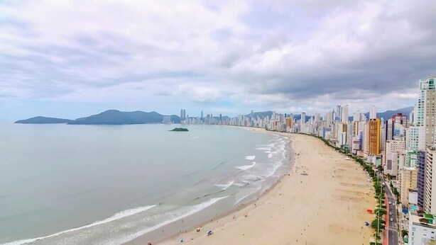 Un paisaje urbano costero con playa y rascacielos.