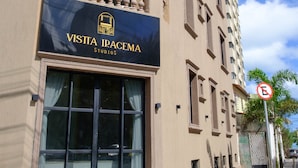 Un bâtiment avec une enseigne indiquant « VISTA IRACEMA STUDIOS » et un panneau interdisant le stationnement.