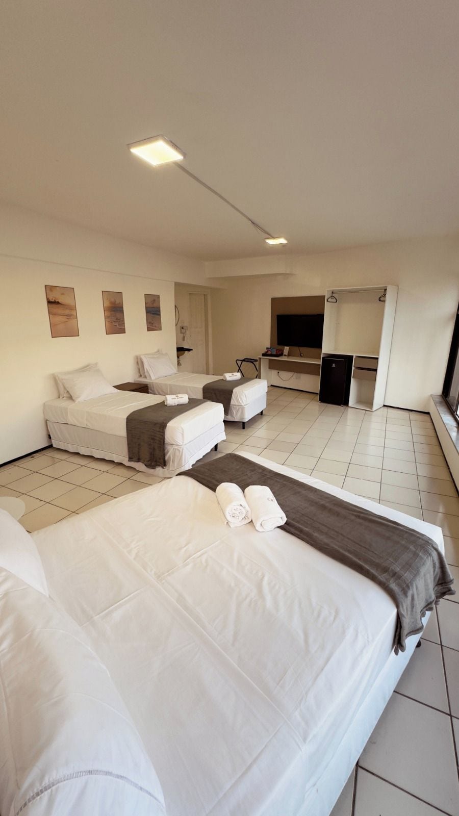 Habitació d'hotel amb dos llits, una taula de treball, televisió i minibar.