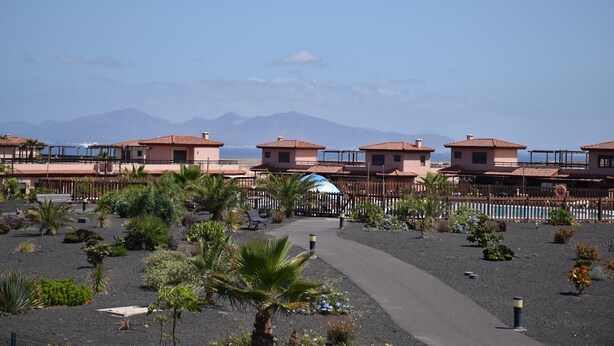 A resort with multiple buildings, a pathway, and a pool area.